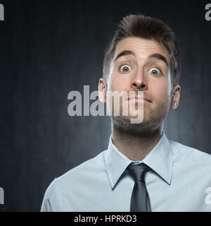 Elegante Jüngling Blick in die Kamera, die Überraschung zum Ausdruck zu bringen. Stockfoto