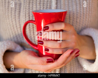 Bild von einer Frau mit einem roten Kaffeetasse Stockfoto