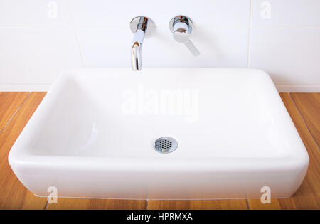 Weißes Porzellan-Waschbecken und verchromten Armaturen im Badezimmer. Stockfoto