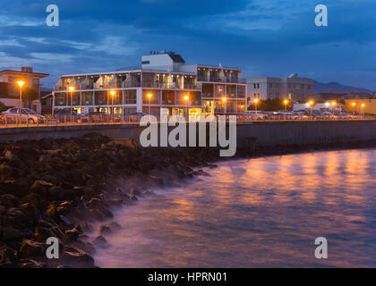 Dunedin, Otago, Neuseeland. Blick entlang der beleuchteten Promenade in der Abenddämmerung, St Clair Hotel St Clair Prominente. Stockfoto