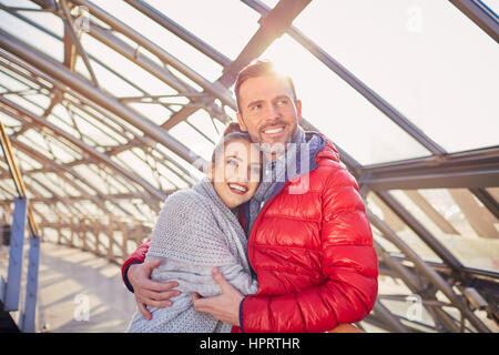 Glückliches Paar umarmt zusammen während der kalten Wintertag in Stadt Stockfoto