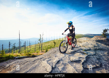 Weibliche MTB Mountainbiker genießt die Aussicht während der sonnigen Tag in Bergen Stockfoto