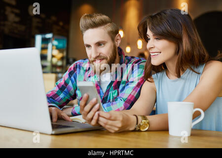 Zwei glückliche Freunde arbeiten mit Laptop im café Stockfoto