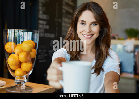 Glücklich, junge Frau mit Kaffee im café Stockfoto