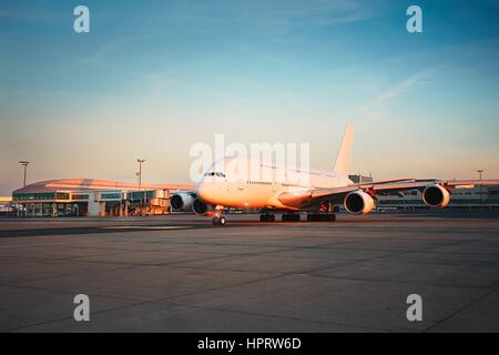 Verkehr des Flughafens bei Sonnenuntergang. Riesige Flugzeug ist zur Startbahn rollen. Stockfoto