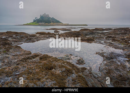 Dawn erschossen am nebligen Morgen mit langer Belichtungszeit von St Michaels Mount mit Rock Pool im Vordergrund, West Cornwall, England, UK im Februar Stockfoto