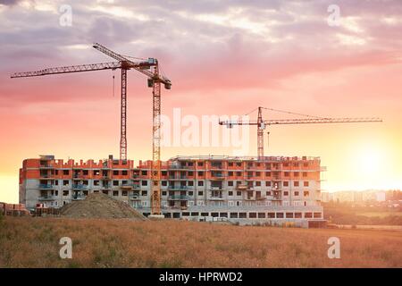 Baustelle mit Kränen auf den traumhaften Sonnenuntergang. Bau des neuen Wohnhauses. Prag, Tschechische Republik. Stockfoto