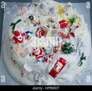 Traditionell eingerichtete Weihnachtskuchen. Geeiste Obstkuchen mit Figuren, Bäume, Weihnachtsmann und Schneemann. Stockfoto