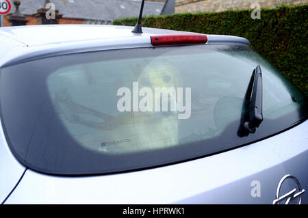 Einsamen Hund leider Blick aus einer Heckscheibe eines Autos, wartet auf seinen Meister Stockfoto