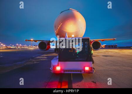 Geschäftigen Flughafen in der Nacht. Drücken Sie hinten das Flugzeug vor dem Flug. Stockfoto