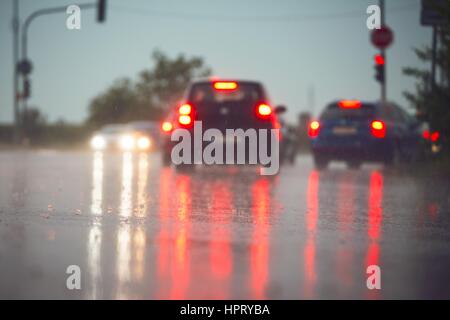 Verkehr in regnerischen Tag in der Stadt.  Blick von der Ebene der Asphalt. Selektiven Fokus auf nasser Fahrbahn. Stockfoto