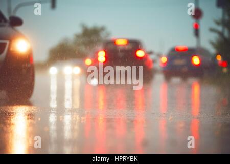 Verkehr in regnerischen Tag in der Stadt.  Blick von der Ebene der Asphalt. Selektiven Fokus auf nasser Fahrbahn. Stockfoto