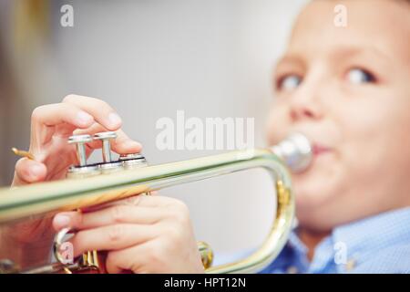 Kleiner Junge spielt die Trompete zu Hause Stockfoto