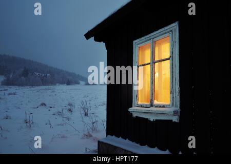 Nacht in Bergen - Holzhaus in Winterlandschaft Stockfoto