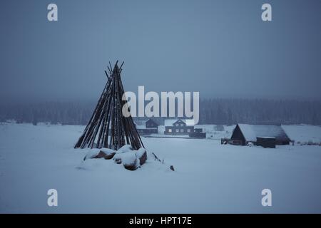 Nacht in Bergen - Holzhaus in Winterlandschaft Stockfoto