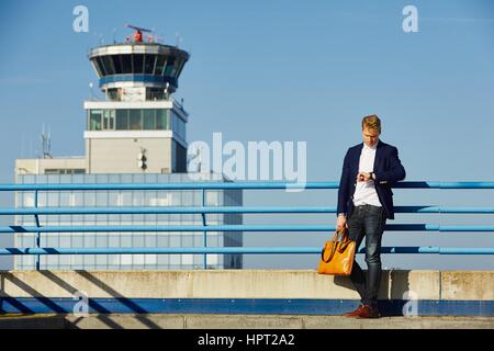 Gut aussehend Geschäftsmann wartet am Flughafen Stockfoto