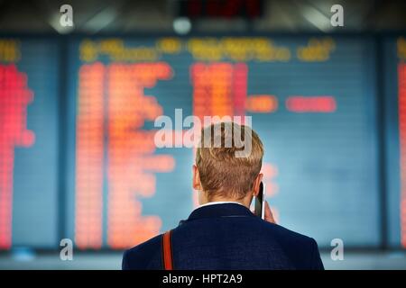 Junger Geschäftsmann wartet am Flughafen Stockfoto