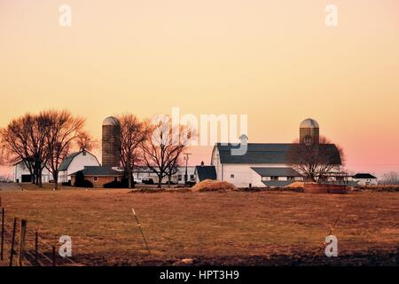 Dämmerung, kurz nach Sonnenuntergang, steigt auf einer Molkerei an einem Winterabend im Nordosten von Illinois in der Gemeinschaft von South Elgin, Illinois, USA. Stockfoto