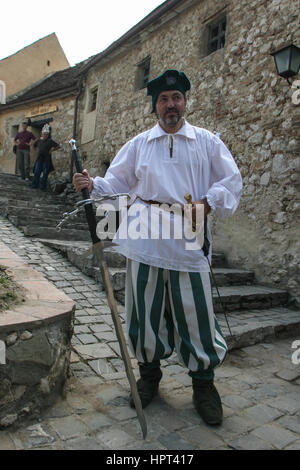 Rosenau, Rumänien, 4. Juli 2009: Ein Leitfaden gekleidet in mittelalterlicher Tracht Posen in mittelalterlichen Festung Rasnov, Grafschaft Brasov, Rumänien. Stockfoto