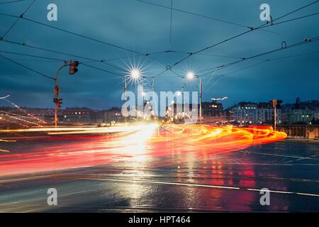 Lichtspuren auf der Kreuzung in regnerischen Nacht in der Stadt. Prag, Tschechische Republik. Stockfoto