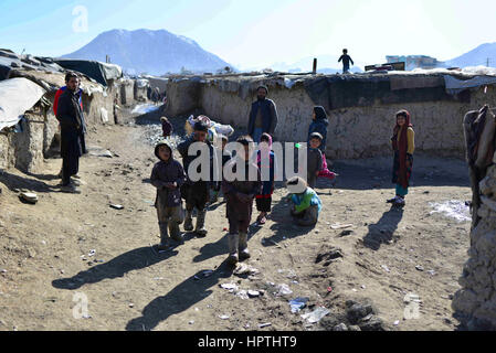 Kabul, Afghanistan. 23. Februar 2017. Foto aufgenommen am 23. Februar 2017 zeigt Kinder und die Schlamm-Gebäude im nördlichen Stadtteil von Kabul, Afghanistan. Winter hat fast bedeckt, Afghanistan, Auswirkungen auf das Leben der armen Familien, vor allem diejenigen, die keine Erwärmung Ausrüstung, sauberes Wasser oder genug zu essen, mit dem kalten Wetter zu bewältigen haben. In den nördlichen Stadtteil von Kabul viele Leben noch immer in Schlamm Gebäuden und haben kein Geld zum Kauf von Holz, Feuer. Bildnachweis: Dai He/Xinhua/Alamy Live-Nachrichten Stockfoto