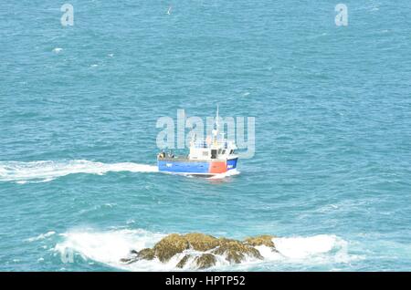 Newquay Cornwall, Vereinigtes Königreich - 1. Juli 2016: Kleine Fischerboote Boot Wityh Felsen im Vordergrund Stockfoto