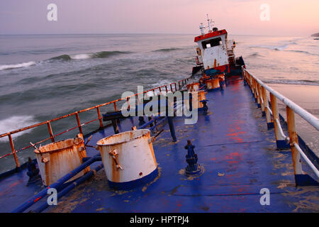 Schiffswrack an der Küste auf farbenfrohen Sonnenuntergang Hintergrund Stockfoto