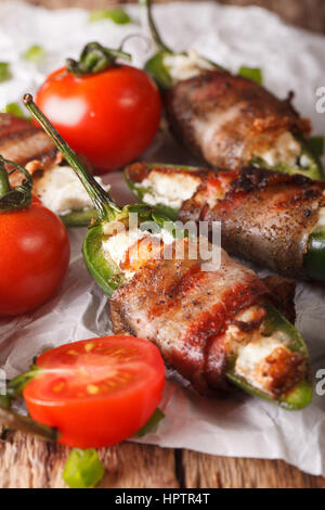 Geröstete Jalapeno Paprika gefüllt mit Käse eingewickelt in Speck-close-up auf dem Tisch. vertikale Stockfoto