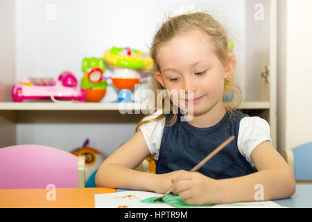 Entzückenden Kind Mädchen zeichnet einen Pinsel und malt im Kinderzimmer. Kind in den Kindergarten in Montessori-Vorschule. Stockfoto