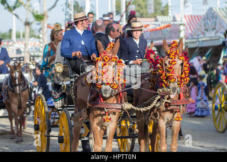 Sevilla, Spanien - 25 APR: Leute gekleidet in traditionellen Kostümen Reiten Pferdekutschen auf der Feria de Abril am 25. April 2014 in Sevilla, Spanien Stockfoto