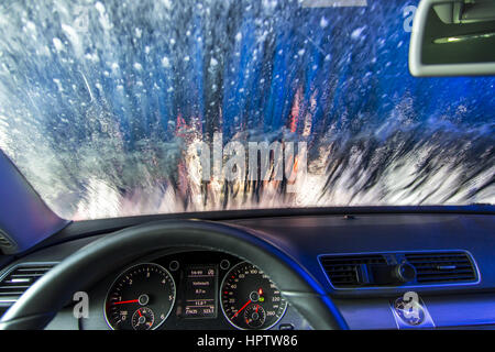 Mietwagen in einer automatischen Waschanlage-Site, Reinigungsschaum, versprüht rotierende Reinigungsbürste, Stockfoto