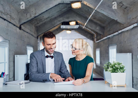 Zwei Business-Manager analysieren Vertrag im modernen Büro. Stockfoto