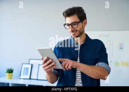 Glücklich Webdesigner mit digitalen Tablet arbeiten vom home-office Stockfoto