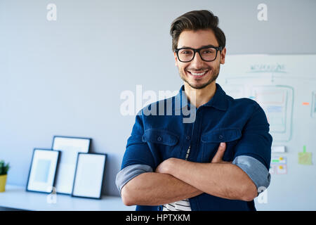 Happy Website-Designer, stehend im Büro mit Brille Stockfoto