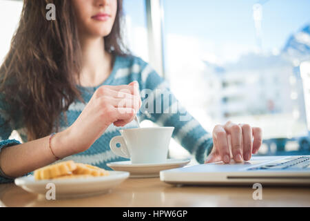 Schöne Mädchen an der Bar eine Kaffeepause und arbeiten auf einem Computer Stockfoto