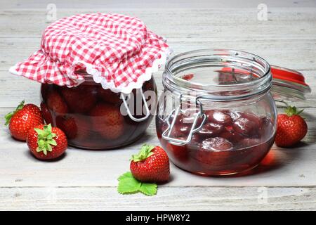 Haus in Dosen Erdbeeren auf Holztisch Stockfoto