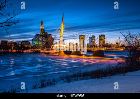 Winnipeg, beleuchtete Provencher Brücke über gefrorenen roten Fluss in der Nacht. Stockfoto
