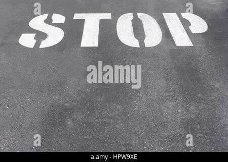 Wort Stop geschrieben am Asphalt Straßenbelag Stockfoto