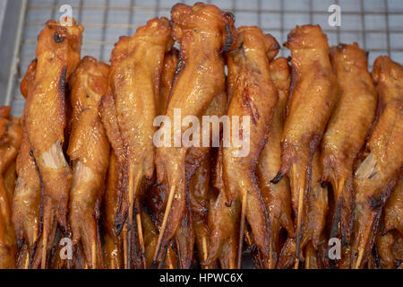 Gebratene Hähnchenflügel auf Kebab-Sticks - gegrillt auf einem Markt in Thailand Stockfoto