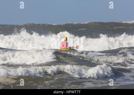 Umgeben von schaumig weißen brechenden Wellen, die ein Kajakfahrer weiter heraus in den Pazifischen Ozean, Ocean Shores, WA Paddel. Stockfoto