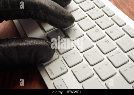 Hand in der schwarzen Handschuh Arten auf Tastatur. Stockfoto