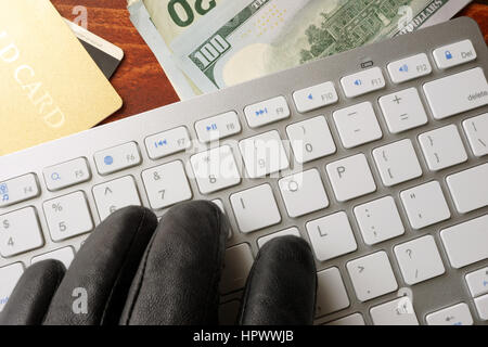 Hacking-Konzept. Hand im schwarzen Handschuh ist auf einer Tastatur tippen. Stockfoto