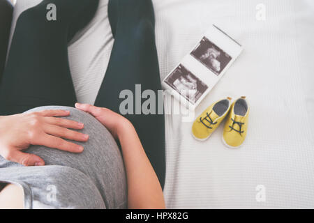 Junge schwangere entspannend auf sofa Stockfoto