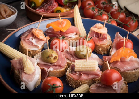 Gemischte spanische Tapas Vorspeisen auf dunklen braunen Holztisch Stockfoto