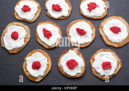 Traditionelle russische hausgemachte Blinis mit Sauerrahm und rotem Kaviar. Ansicht von oben Stockfoto