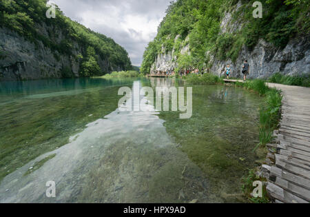 Touristen Fuß entlang der Holzstege in einem von Europas beliebtesten Nationalparks, Nationalpark Plitvicer Seen in Kroatien. Stockfoto