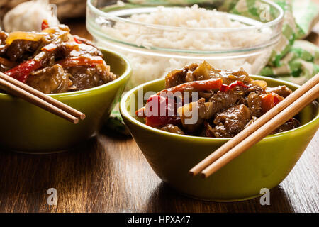 Chinesische klebrige Schweinefleisch Rinderfilet gebraten mit einem süßen und herzhaften Soße mit gekochtem Reis serviert Stockfoto