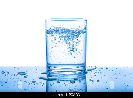 Wasser aus transparentem Glas mit Tropfen und Bläschen über weißen, blauen Hintergrund isoliert, Nahaufnahme Stockfoto