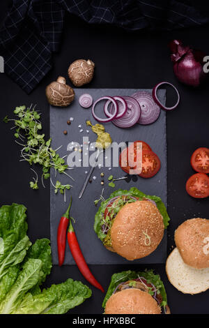 Nahaufnahme der hausgemachte Burger mit frischem Gemüse auf Schiefer. Gesundes Essen Stilleben, Ansicht von oben. Stockfoto