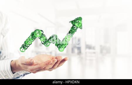 Schließen der Hände halten in Palmen wachsen Grafik gemacht von Zahnrädern Stockfoto